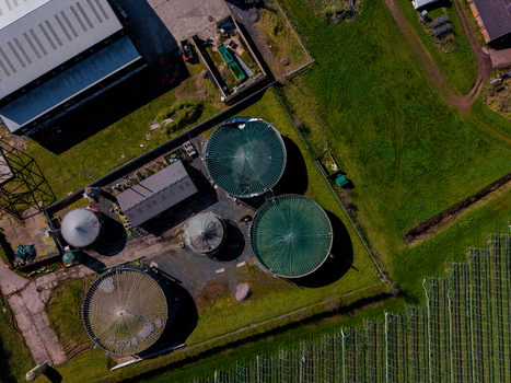 Aerial view of Gnosall Heath featuring industrial storage tanks and agricultural infrastructure surrounded by green fields in Gnosall England United Kingdom. Aerial view of Gnosall Heath featuring industrial storage tanks and agricultural infrastructure surrounded by green fields in Gnosall England United Kingdom.