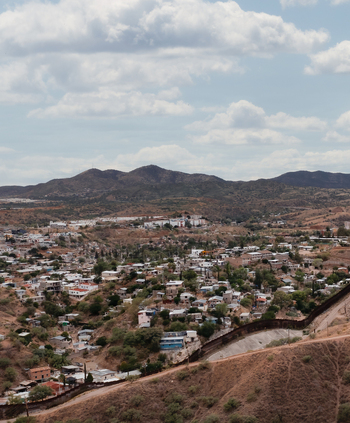 Aerial view of the international border fence separating urban residential areas in the hilly landscape of Nogales Arizona United States.