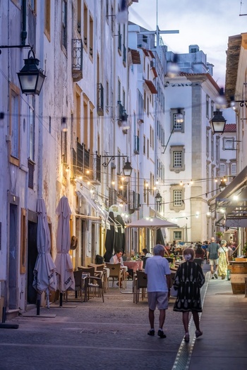 Evora Portugal 08 September 2026 View of a narrow street in the historic center of Evora with traditional white buildings outdoor restaurant seating and string lights. Evora Portugal 08 September 2026 View of a narrow street in the historic center of Evora with traditional white buildings outdoor restaurant seating and string lights.