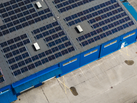 Aerial view of a blue industrial building with solar panels installed on the roof in Riga Latvia. Aerial view of a blue industrial building with solar panels installed on the roof in Riga Latvia.