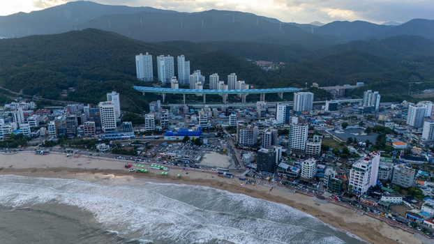 Aerial view of Songjeong dong beach with high rise apartment buildings a coastal highway bridge and sandy shoreline in Busan Busan South Korea. Aerial view of Songjeong dong beach with high rise apartment buildings a coastal highway bridge and sandy shoreline in Busan Busan South Korea.