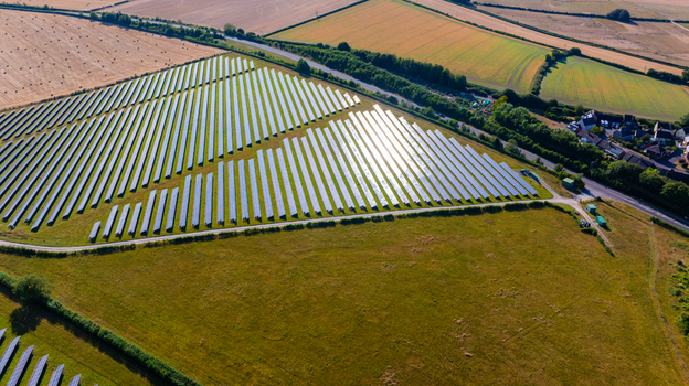 Aerial view of a large solar farm with rows of photovoltaic panels set in green rural fields in Dorset England United Kingdom. Aerial view of a large solar farm with rows of photovoltaic panels set in green rural fields in Dorset England United Kingdom.