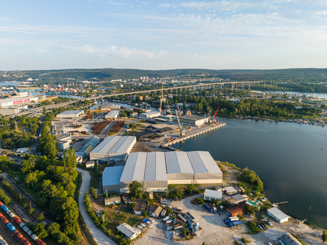 Aerial view of the Southern Industrial Zone featuring large warehouses port facilities railway tracks and a bridge spanning the water in Varna Varna Bulgaria. Aerial view of the Southern Industrial Zone featuring large warehouses port facilities railway tracks and a bridge spanning the water in Varna Varna Bulgaria.