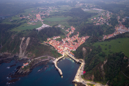 Aerial view of the picturesque coastal village of Cudillero featuring colorful houses nestled in a valley a small harbor and a lighthouse on rocky cliffs at twilight Cudillero Asturias Spain. Aerial view of the picturesque coastal village of Cudillero featuring colorful houses nestled in a valley a small harbor and a lighthouse on rocky cliffs at twilight Cudillero Asturias Spain.