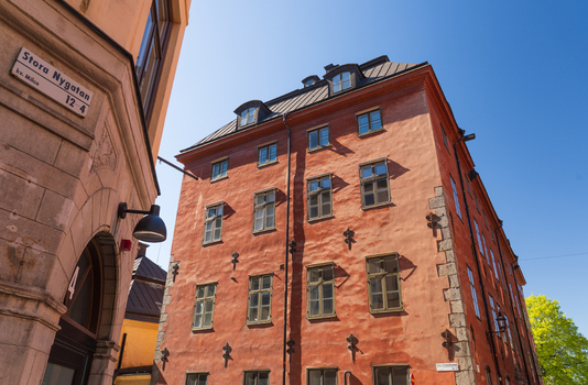 Stockholm Sweden 02 May 2026 View of the historic terracotta colored facade of a building on Stora Nygatan street under a clear blue sky in Gamla Stan.