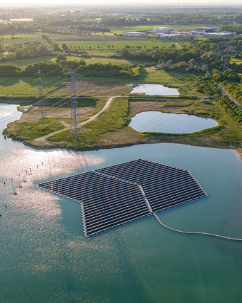 Aerial view of floating solar farm on a lake with power lines and green fields in Bensheim Hessen Germany. Aerial view of floating solar farm on a lake with power lines and green fields in Bensheim Hessen Germany.