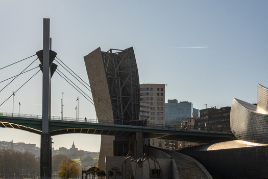 View of the Guggenheim Museum Bilbao with the La Salve Bridge and the Maman spider sculpture under a clear blue sky in Bilbao Euskadi Spain. View of the Guggenheim Museum Bilbao with the La Salve Bridge and the Maman spider sculpture under a clear blue sky in Bilbao Euskadi Spain.