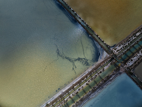 Aerial view of the geometric salt pans with colorful evaporation ponds and narrow water channels in Cagliari Sardinia Italy. Aerial view of the geometric salt pans with colorful evaporation ponds and narrow water channels in Cagliari Sardinia Italy.