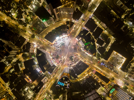 Aerial view of a bustling roundabout illuminated with golden streams of traffic light trails weaving around commercial buildings at night Dhaka Dhaka Division Bangladesh. Aerial view of a bustling roundabout illuminated with golden streams of traffic light trails weaving around commercial buildings at night Dhaka Dhaka Division Bangladesh.