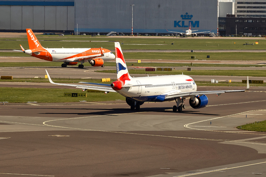 Schiphol Netherlands 16 April 2026 View of British Airways and easyJet airplanes taxiing on the runway at Schiphol Airport with a KLM hangar in the background under bright daylight. Schiphol Netherlands 16 April 2026 View of British Airways and easyJet airplanes taxiing on the runway at Schiphol Airport with a KLM hangar in the background under bright daylight.