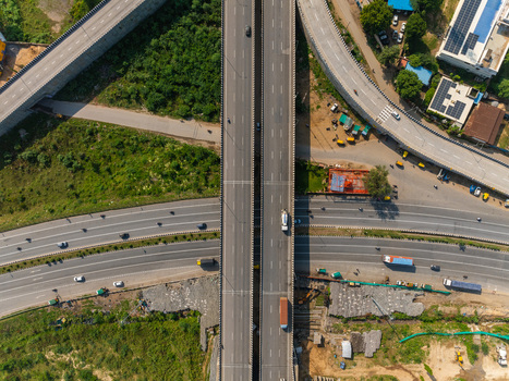 Aerial view of a highway interchange with multiple lanes vehicles and surrounding greenery in Udaipur Rajasthan India. Aerial view of a highway interchange with multiple lanes vehicles and surrounding greenery in Udaipur Rajasthan India.