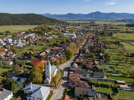 Aerial view of a serene village with a distinctive white church spire vibrant autumn foliage and a winding road framed by distant mountains Klastor pod Znievom Zilina Region Slovakia. Aerial view of a serene village with a distinctive white church spire vibrant autumn foliage and a winding road framed by distant mountains Klastor pod Znievom Zilina Region Slovakia.