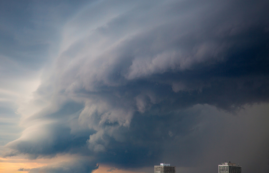 Aerial view of dramatic storm clouds and a shelf cloud formation looming over urban high rise buildings in Toronto Ontario Canada.