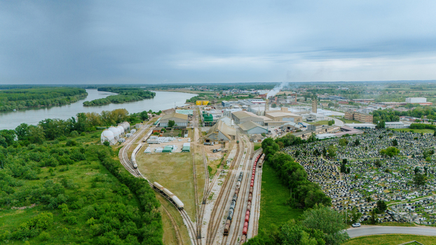 Aerial view of an industrial complex with railway tracks freight trains and a large cemetery near the Sava river in Sabac Vojvodina Serbia. Aerial view of an industrial complex with railway tracks freight trains and a large cemetery near the Sava river in Sabac Vojvodina Serbia.