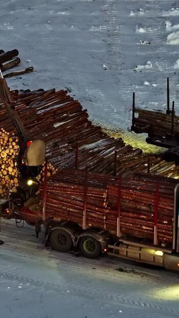 Aerial view of logging truck on snow in Latvia.