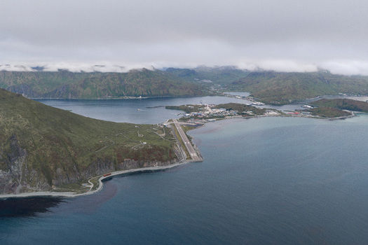 Aerial view of the Unalaska Airport runway situated on a narrow strip of land between the mountains and the sea in Unalaska Alaska United States.