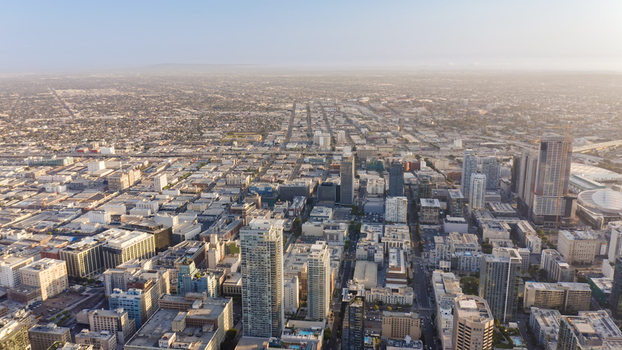 Aerial view of the sprawling Los Angeles skyline featuring modern skyscrapers dense urban grid and distant horizon under a clear sky in Los Angeles California United States.