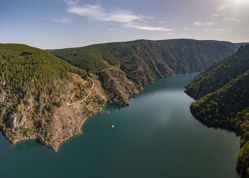 Aerial view of the Ribeira Sacra canyon with deep blue river waters steep forested slopes and winding paths in Lugo Orense Spain. Aerial view of the Ribeira Sacra canyon with deep blue river waters steep forested slopes and winding paths in Lugo Orense Spain.