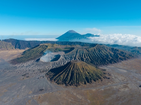 Aerial view of Mount Bromo volcano complex with its dramatic crater rugged slopes and surrounding volcanic landscape in Tosari East Java Indonesia. Aerial view of Mount Bromo volcano complex with its dramatic crater rugged slopes and surrounding volcanic landscape in Tosari East Java Indonesia.
