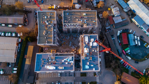 Aerial view of construction site with red cranes piercing the skyline buildings rising against the urban sprawl Prague 9 Prague Czechia. Aerial view of construction site with red cranes piercing the skyline buildings rising against the urban sprawl Prague 9 Prague Czechia.
