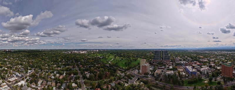 Aerial view of Cherry Creek winding through the urban landscape with lush trees high rise buildings and residential neighborhoods under a cloudy sky in Denver Colorado United States. Aerial view of Cherry Creek winding through the urban landscape with lush trees high rise buildings and residential neighborhoods under a cloudy sky in Denver Colorado United States.