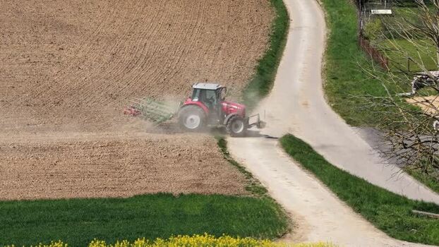 Aerial view of tractor plowing field France.
