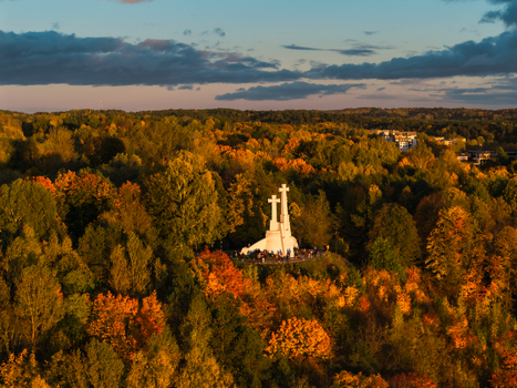 Aerial view of the Three Crosses monument standing prominently amid the vibrant autumn foliage a beacon against the colorful canopy Vilnius Lithuania. Aerial view of the Three Crosses monument standing prominently amid the vibrant autumn foliage a beacon against the colorful canopy Vilnius Lithuania.