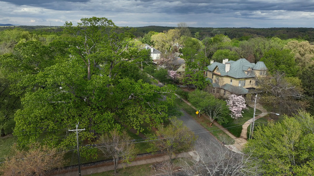 Aerial view of a historic house surrounded by lush green spring trees and a quiet street in a residential neighborhood in Lynchburg Virginia United States. Aerial view of a historic house surrounded by lush green spring trees and a quiet street in a residential neighborhood in Lynchburg Virginia United States.