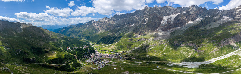 Aerial view of the alpine village of Breuil Cervinia nestled in a lush green valley surrounded by rocky mountain peaks and winding roads in Breuil Cervinia Aosta Valley Italy. Aerial view of the alpine village of Breuil Cervinia nestled in a lush green valley surrounded by rocky mountain peaks and winding roads in Breuil Cervinia Aosta Valley Italy.