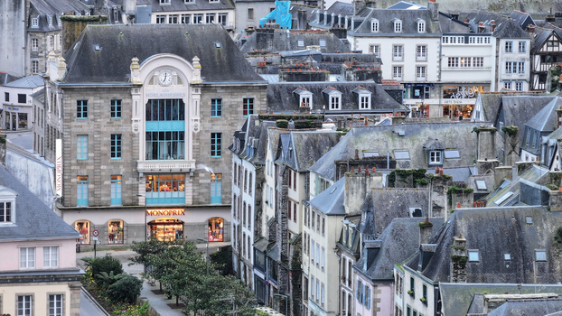 Aerial view of the historic town center featuring the Monoprix building traditional stone architecture and slate rooftops under soft daylight Morlaix Bretagne France. Aerial view of the historic town center featuring the Monoprix building traditional stone architecture and slate rooftops under soft daylight Morlaix Bretagne France.