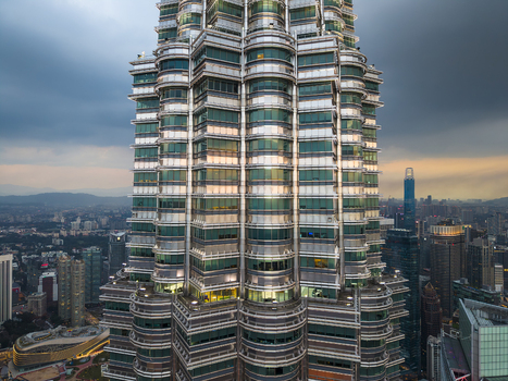 Kuala Lumpur Malaysia 11 March 2026 Aerial view of the Petronas Twin Towers facade with the city skyline and a sunset sky in the background.