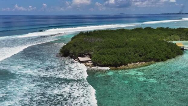 Aerial view of tropical island and turquoise ocean in Maldives.