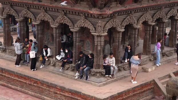 View of people sitting at a historic temple in Kathmandu Nepal.