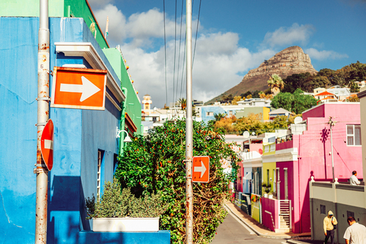 View of the colorful houses in Bo Kaap with street signs Lion s Head mountain and people walking on the street Cape Town Western Cape South Africa. View of the colorful houses in Bo Kaap with street signs Lion s Head mountain and people walking on the street Cape Town Western Cape South Africa.