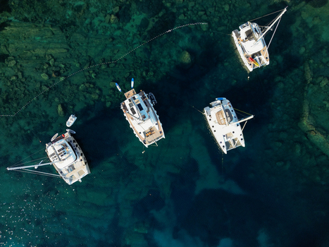 Aerial view of catamarans anchored in the clear turquoise waters near the island of Hvar showcasing the vibrant sea and rocky seabed in Split Dalmatia County Croatia.