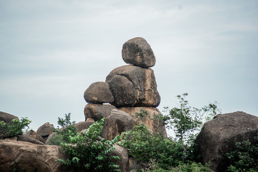 View of naturally stacked granite boulders surrounded by lush green vegetation under a cloudy sky in Jos North Plateau Nigeria. View of naturally stacked granite boulders surrounded by lush green vegetation under a cloudy sky in Jos North Plateau Nigeria.