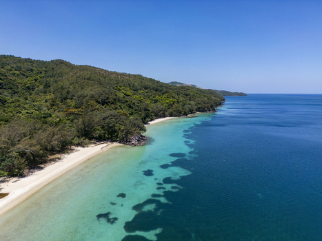 Aerial view of the pristine white sand beach and turquoise waters of Guanaja island surrounded by lush tropical forests Guanaja Bay Islands Department Honduras. Aerial view of the pristine white sand beach and turquoise waters of Guanaja island surrounded by lush tropical forests Guanaja Bay Islands Department Honduras.