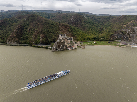 Aerial view of the historic Golubac Fortress situated on the rocky banks of the Danube river with a large cruise ship sailing past in Golubac Branicevski okrug Serbia. Aerial view of the historic Golubac Fortress situated on the rocky banks of the Danube river with a large cruise ship sailing past in Golubac Branicevski okrug Serbia.