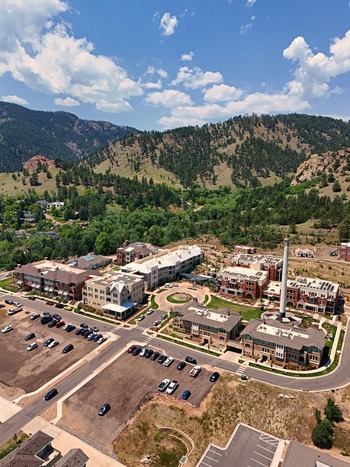 Aerial view of a residential complex with a tall chimney parking lots and surrounding foothills in Boulder Colorado United States. Aerial view of a residential complex with a tall chimney parking lots and surrounding foothills in Boulder Colorado United States.
