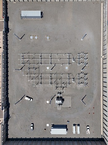 Aerial view of an electrical substation with power lines transformers and utility vehicles parked on a gravel lot in Thornton Colorado United States. Aerial view of an electrical substation with power lines transformers and utility vehicles parked on a gravel lot in Thornton Colorado United States.