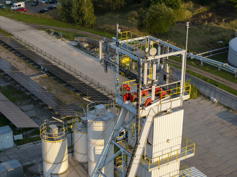 Aerial view of the Wieliczka Salt Mine shaft structure featuring industrial metal framework red pulleys storage tanks and adjacent solar panels in Wieliczka Lesser Poland Voivode Poland.
