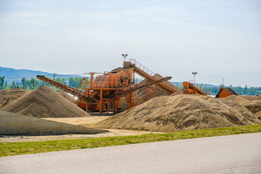 View of industrial sand processing machinery with conveyor belts and large piles of gravel under a clear sky in Novi Sad Vojvodina Serbia. View of industrial sand processing machinery with conveyor belts and large piles of gravel under a clear sky in Novi Sad Vojvodina Serbia.