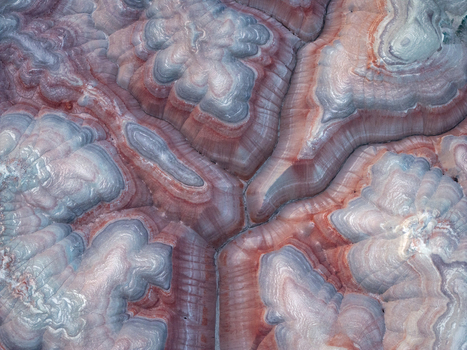 Aerial view of the colorful Bentonite Hills featuring vibrant red and grey layered rock formations and intricate erosion patterns Hanksville Utah United States.