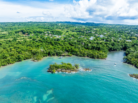 Aerial view of the turquoise waters and lush green coastline of Rio San Juan with a small island and boats in the bay Rio San Juan Maria Trinidad Sanchez Dominican Republic. Aerial view of the turquoise waters and lush green coastline of Rio San Juan with a small island and boats in the bay Rio San Juan Maria Trinidad Sanchez Dominican Republic.