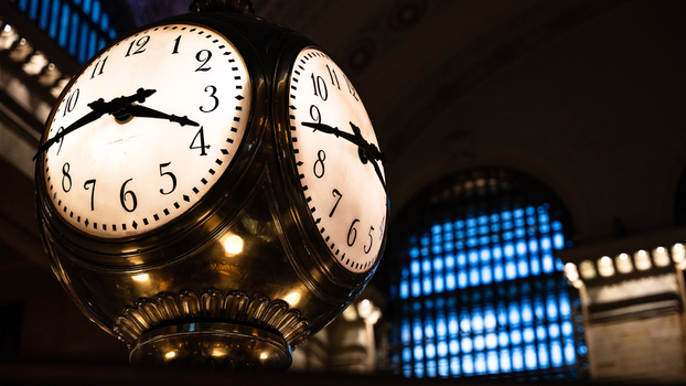 View of the iconic four faced brass clock at Grand Central Terminal with glowing faces and intricate metalwork set against the dimly lit main concourse in Kings County New York United States. View of the iconic four faced brass clock at Grand Central Terminal with glowing faces and intricate metalwork set against the dimly lit main concourse in Kings County New York United States.