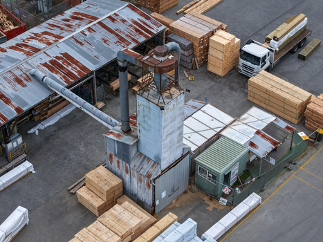 Melbourne Australia 25 September 2026 Aerial view of a timber facility with a large industrial dust collection system stacks of lumber and a delivery truck in a yard.