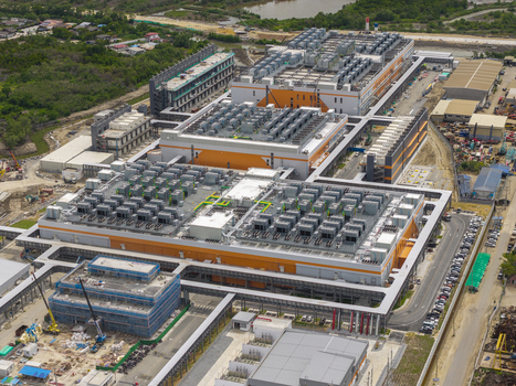 Aerial view of a large hyperscale data center facility with industrial buildings rooftop cooling units parking areas and construction infrastructure in Bangkok Bangkok Thailand. Aerial view of a large hyperscale data center facility with industrial buildings rooftop cooling units parking areas and construction infrastructure in Bangkok Bangkok Thailand.