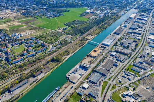 Aerial view of the Canal du Rh&ocirc;ne au Rhin cutting through the city juxtaposing industrial zones with serene residential areas Sausheim Grand Est France.