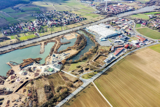 Aerial view of the town of Buttenheim featuring the Main Danube Canal industrial facilities and vast agricultural fields under a clear sky in Buttenheim Bavaria Germany. Aerial view of the town of Buttenheim featuring the Main Danube Canal industrial facilities and vast agricultural fields under a clear sky in Buttenheim Bavaria Germany.