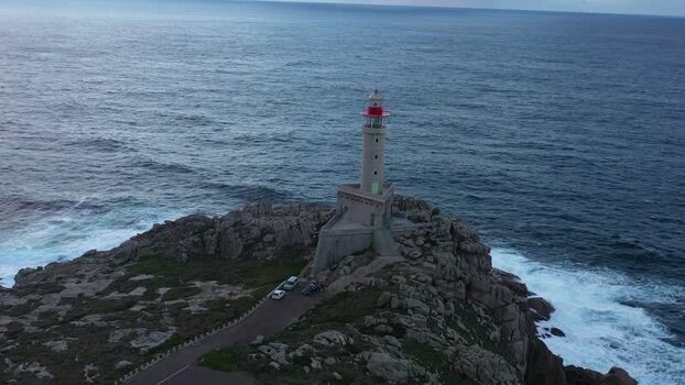 Aerial view of Faro de Punta Nariga on rocky cliffs Spain.